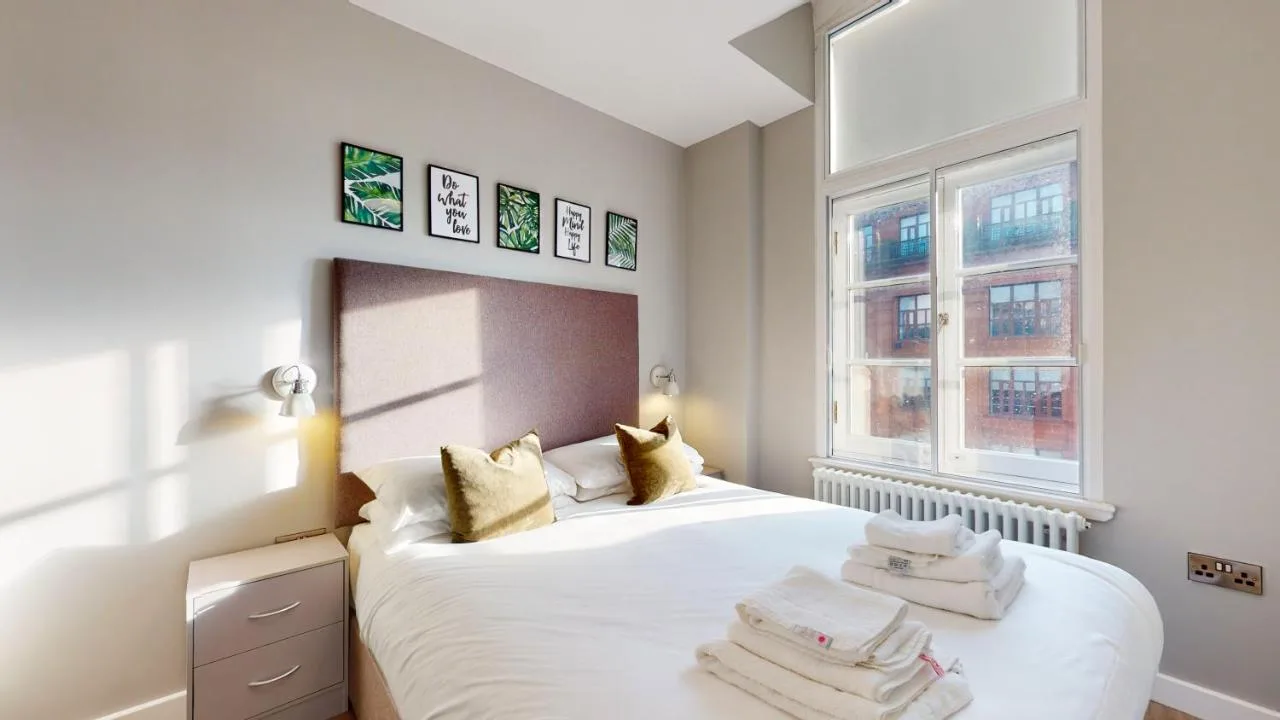 A bedroom with a bed and two windows at Glassford Residence in Glasgow